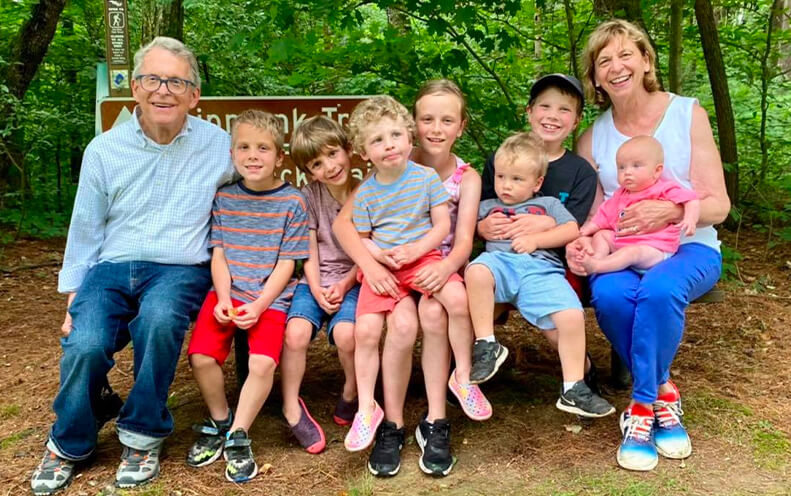 Governor Mike DeWine and his wife Fran outdoors with their grandchildren.